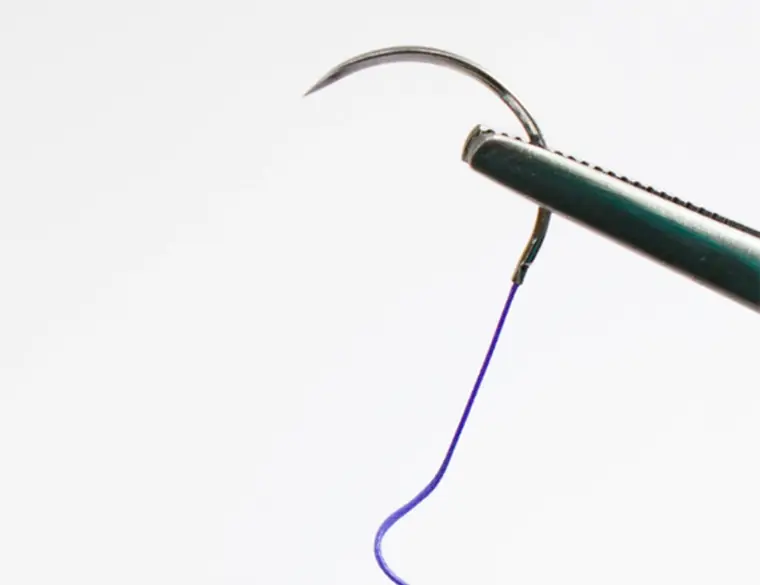 Coated absorbable surgical suture swaged onto a precision needle